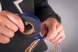 Insulating electrical wires with electrical tape.