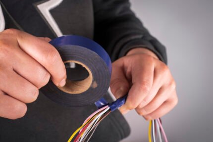 Insulating electrical wires with electrical tape.